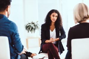 Shot of a young therapist speaking to a couple during a counseling session